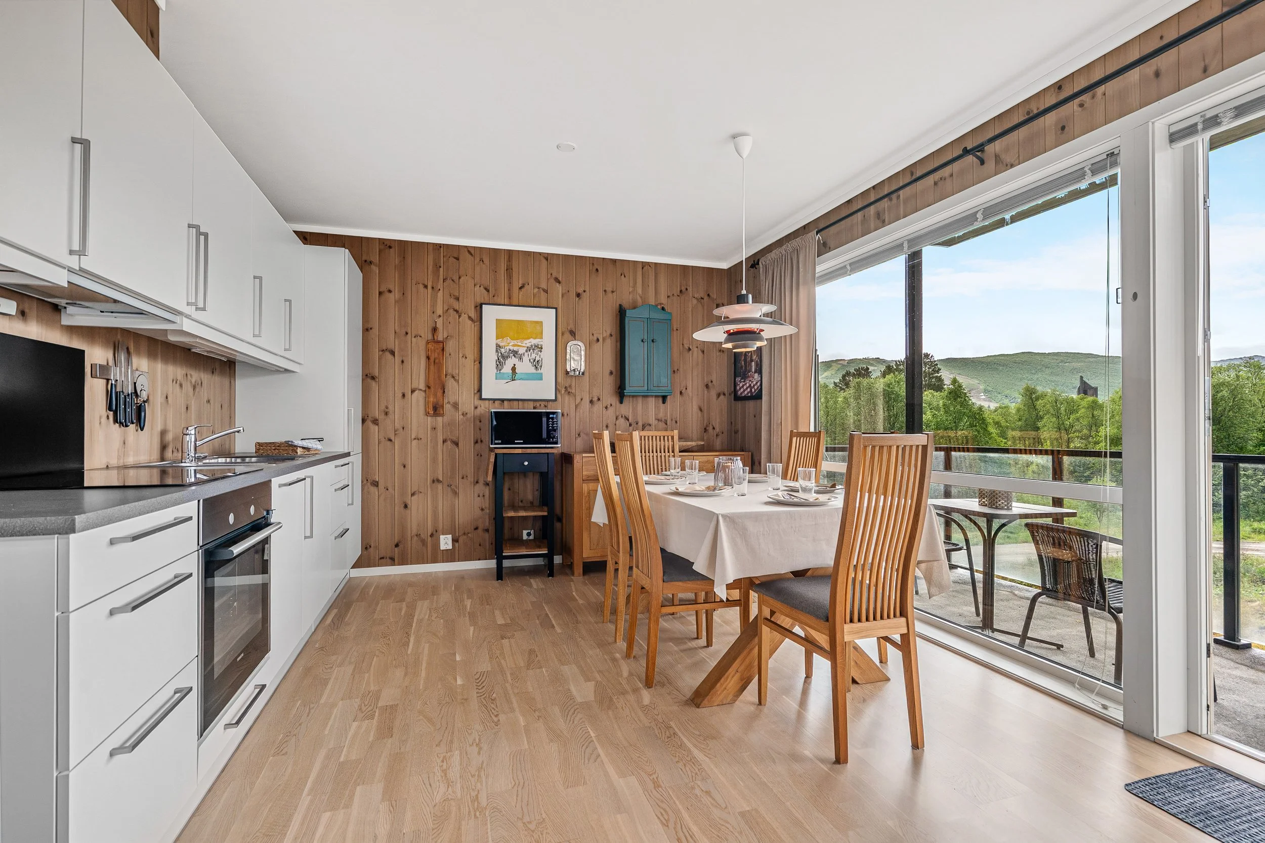 Bright and cozy kitchen with dining table. Large windows with natural light. Photo
