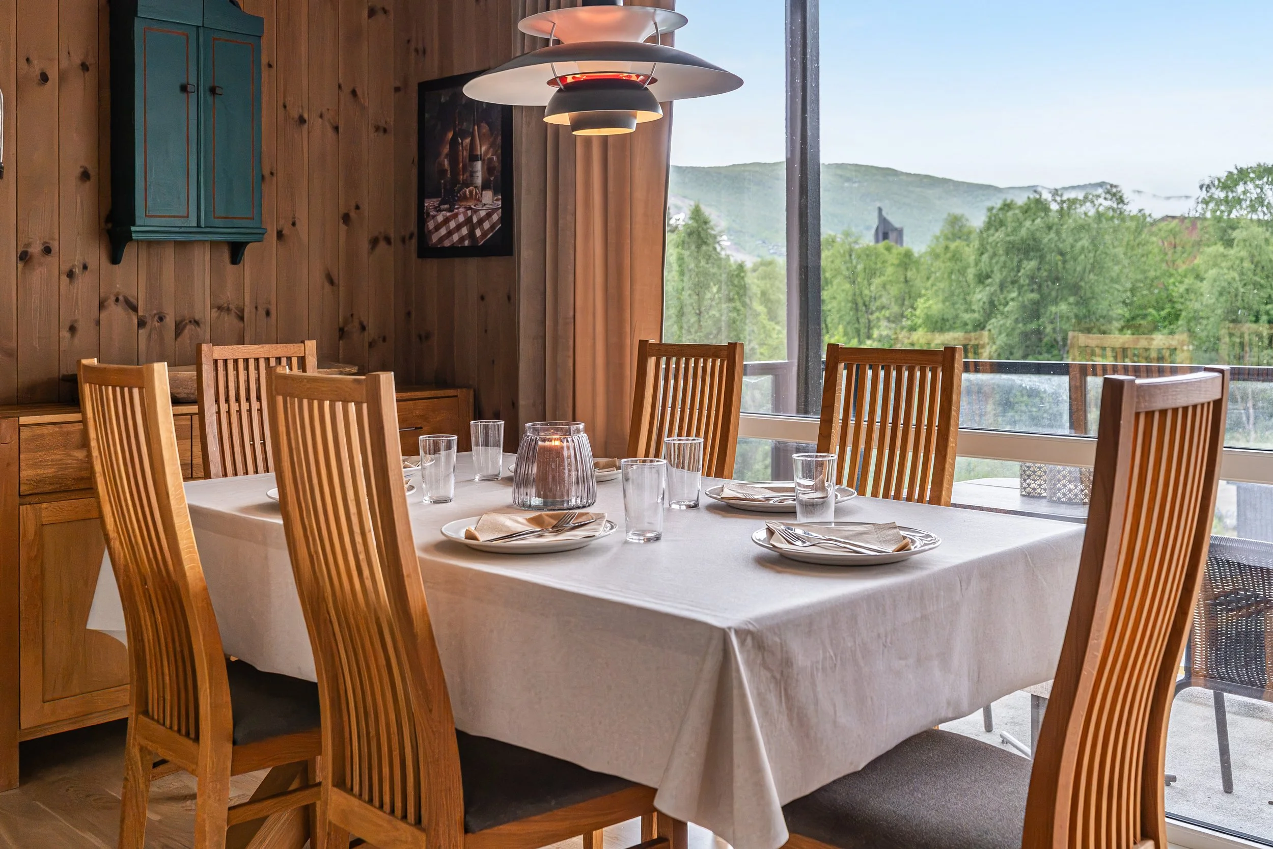 Set dining table. Large window with view of greenery. Photo