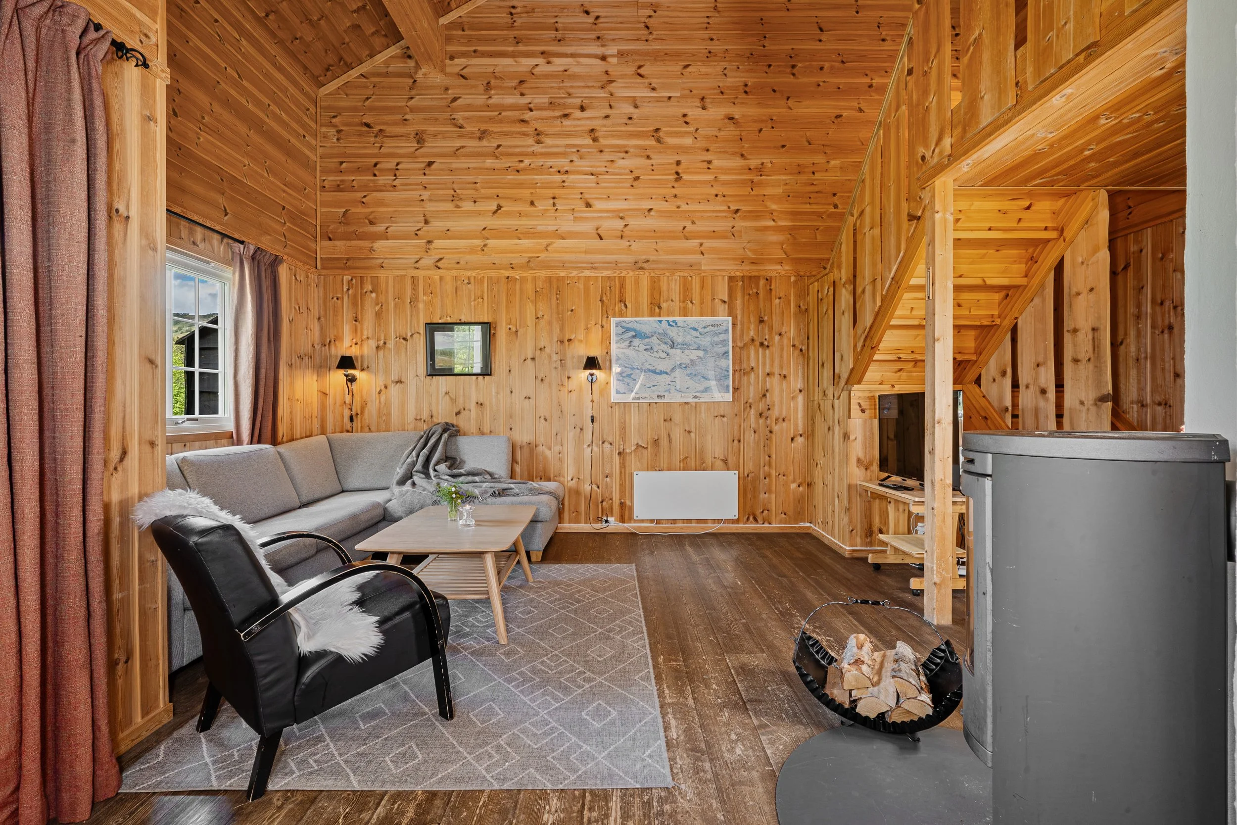 Living room in a traditional cottage, with a fireplace and a sofa corner. Photo