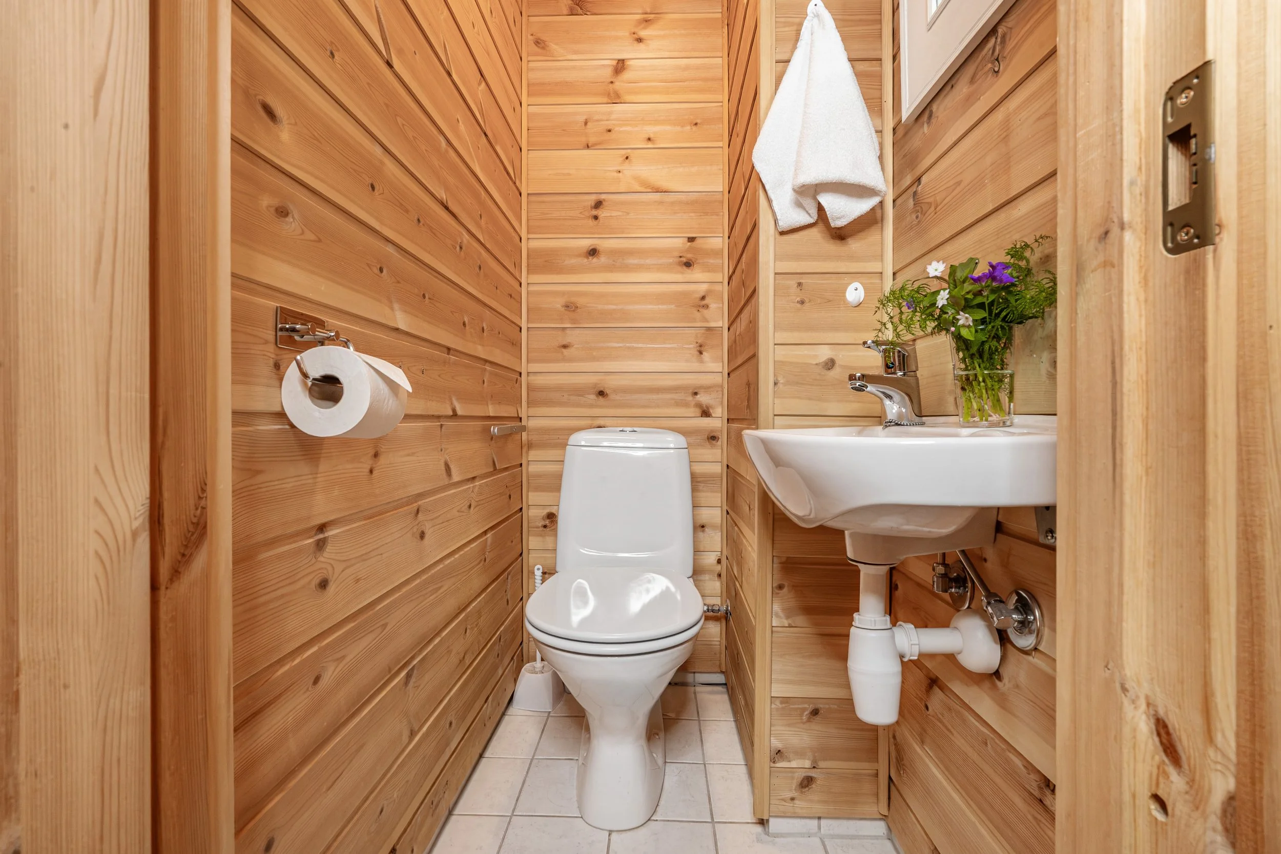 Bathroom with toilet and sink. Decorated with a flower. Photo