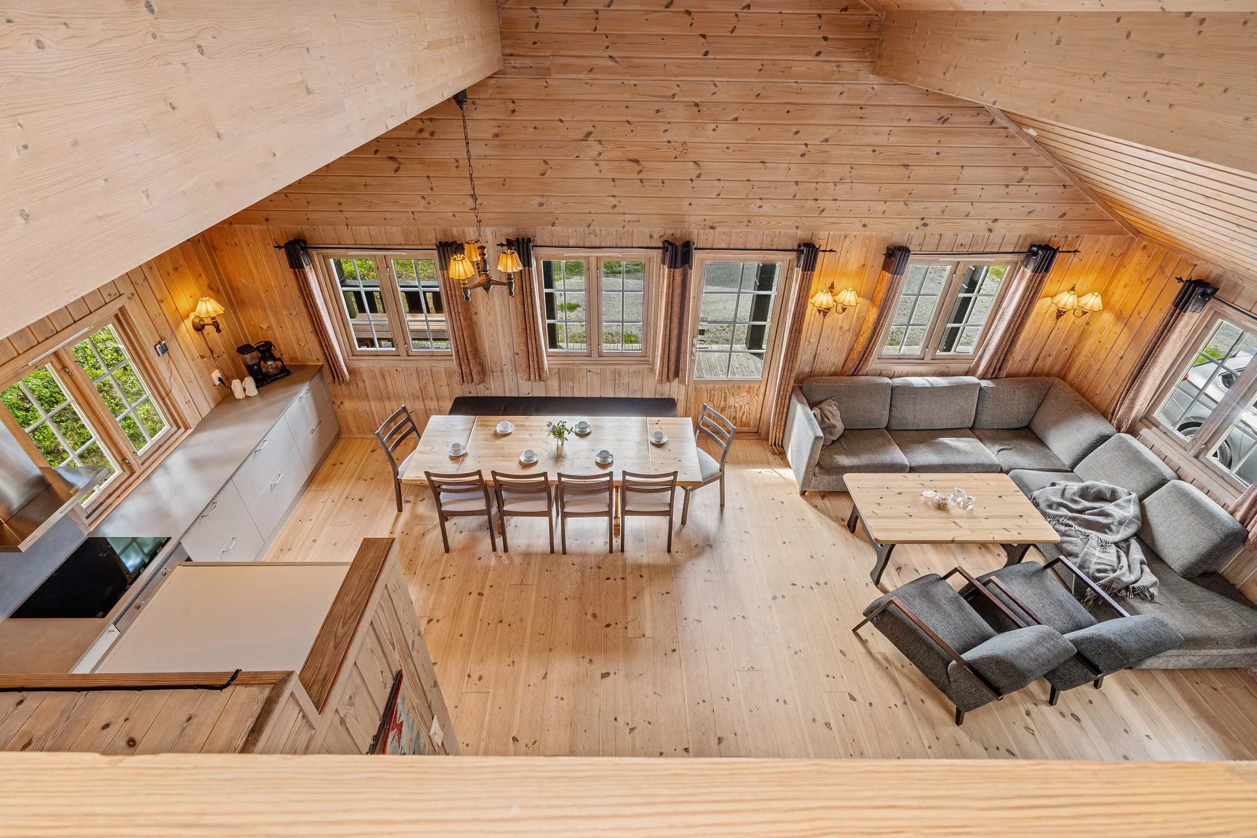 Overview of the living room and kitchen from the loft. Large dining table and sofa area. Photo