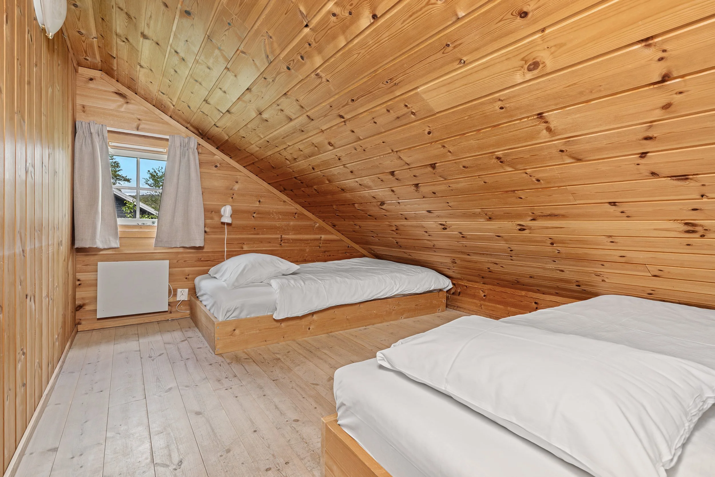 Bedroom on the loft with two low single beds. Photo