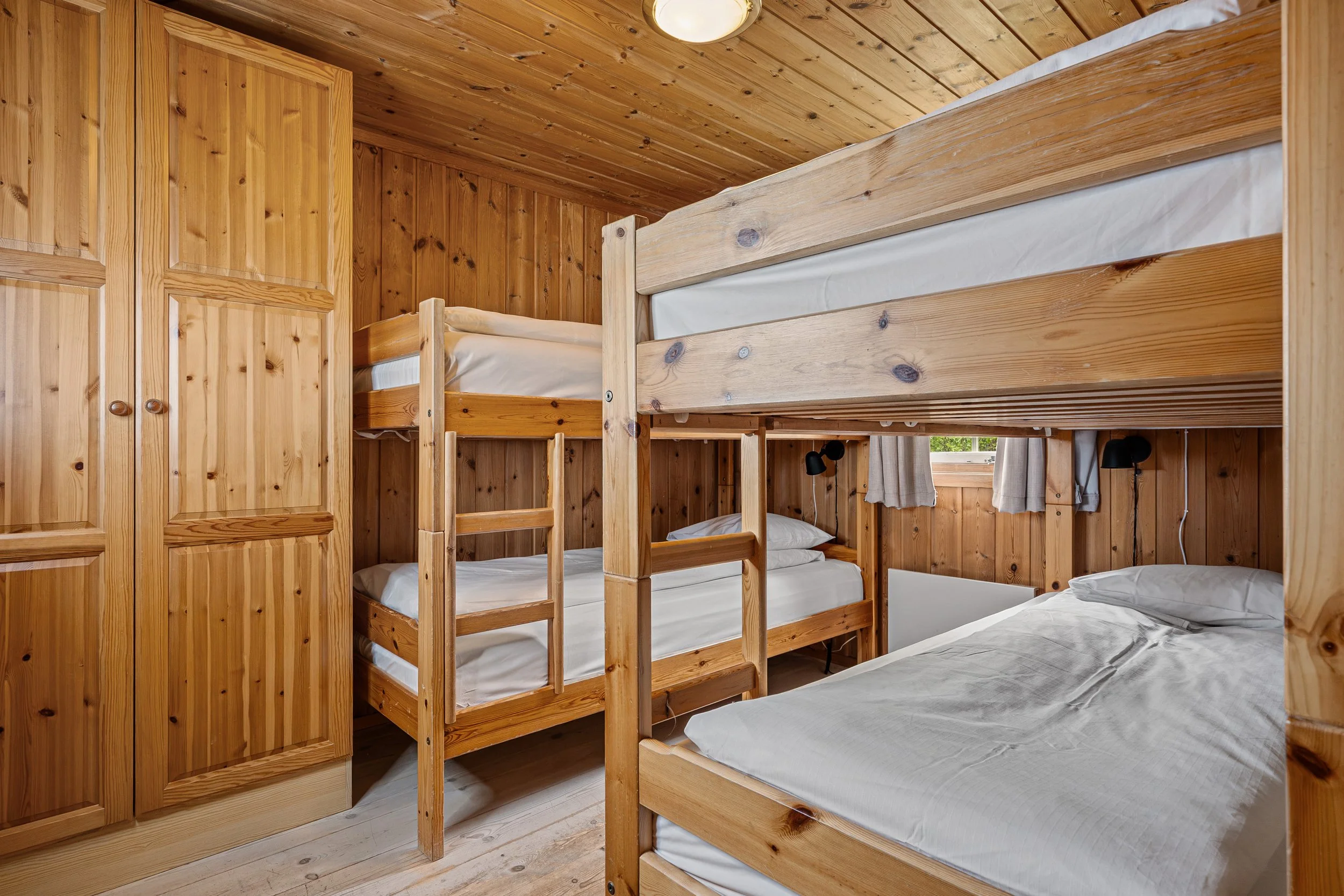 Bedroom with two made-up bunk beds. Photo