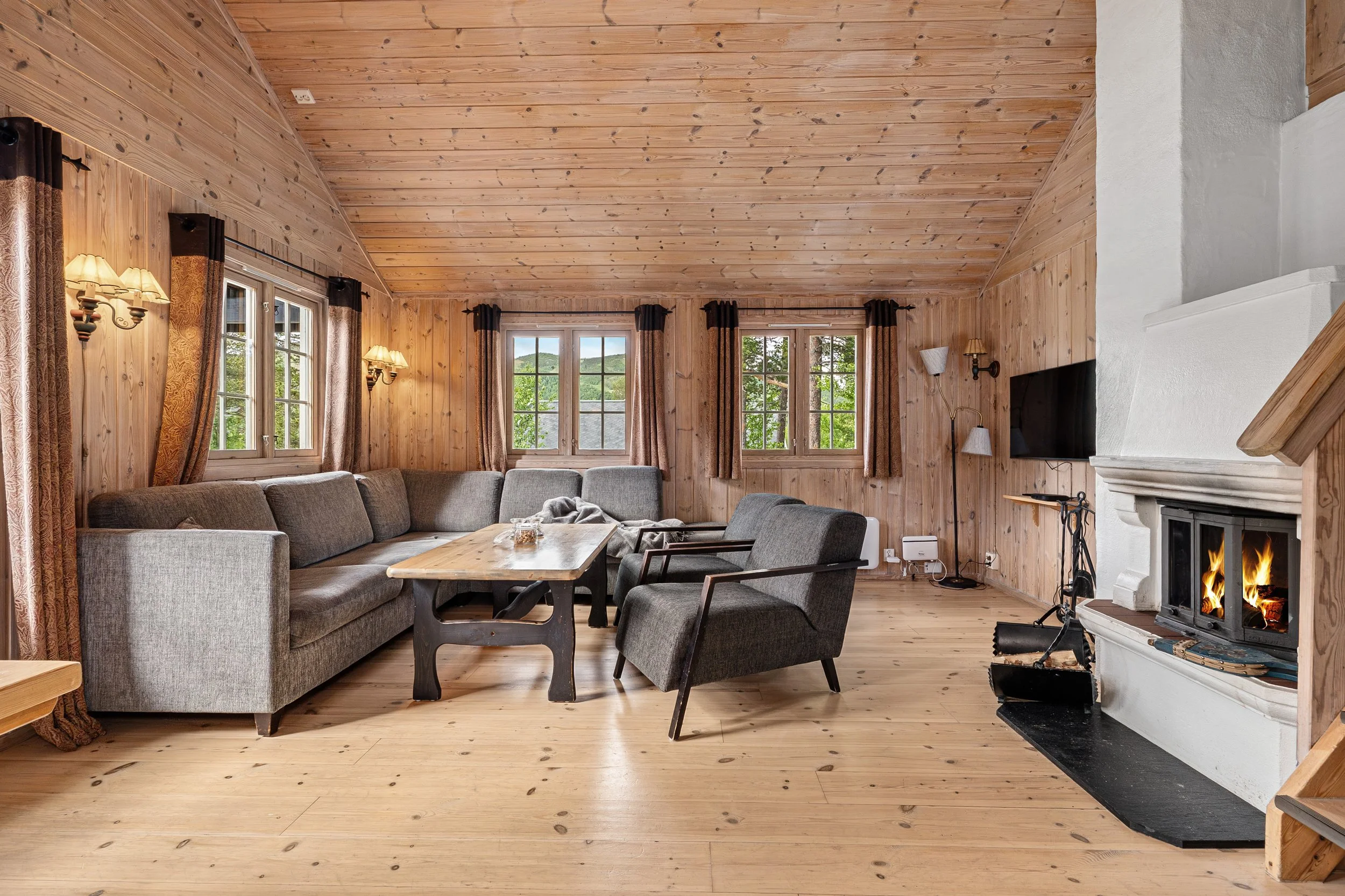 Living room with fireplace, sofa, coffee table and many windows. Photo