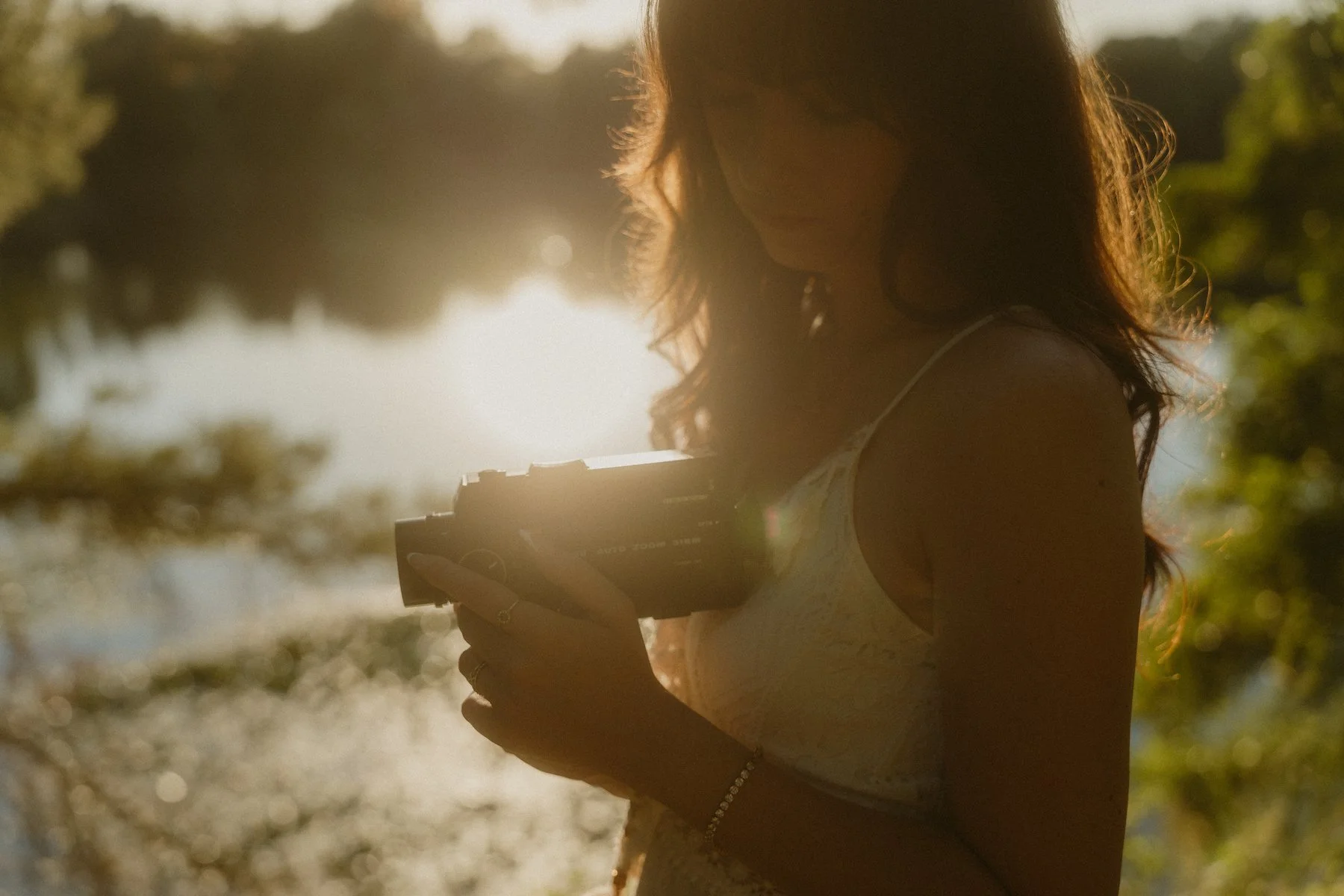 Eine Fotografin mit analoger Kamera im warmen Abendlicht am Steinrodsee in Weiterstadt-Gräfenhausen, ruhig und stimmungsvoll am Wasser