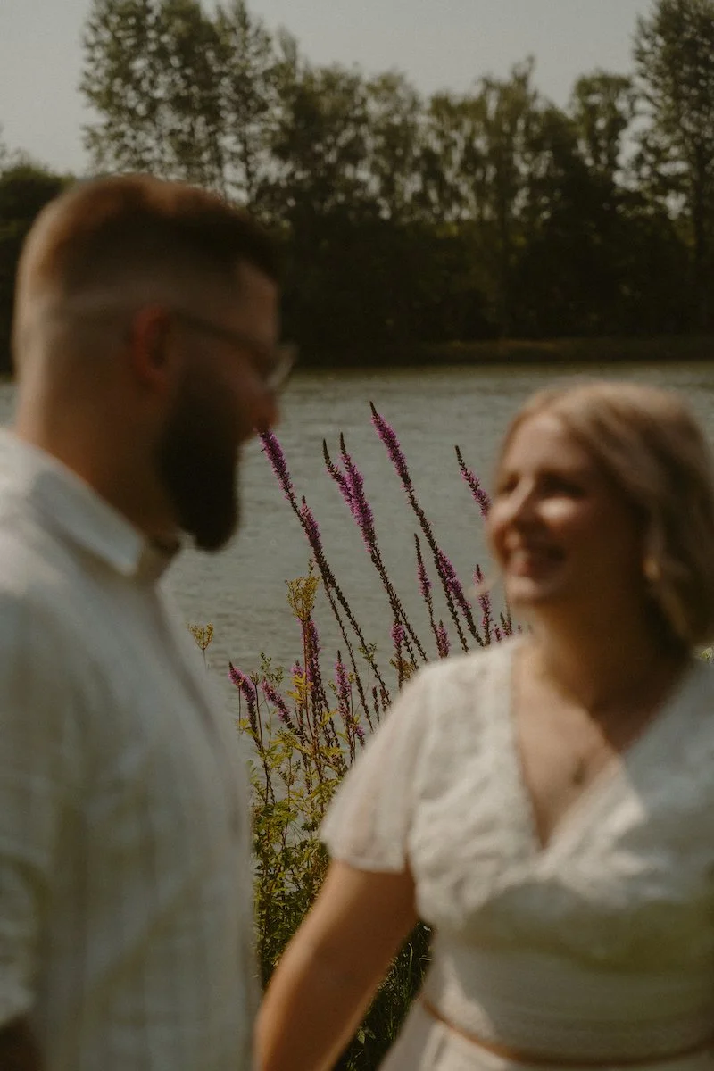 Ein Brautpaar lacht sich am See in Hahn am See an, festgehalten von einem Hochzeitsfotograf aus Darmstadt mit Gespür für echte Nähe.