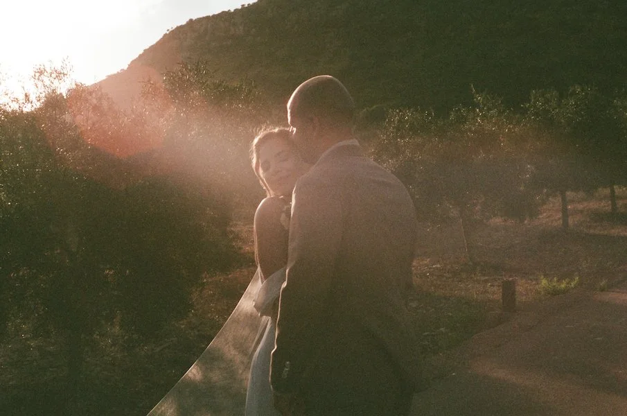 Analoge Hochzeitsfotografie eines innigen Brautpaars bei einer freien Trauung auf der Finca ses Voltes auf Mallorca im sanften Gegenlicht
