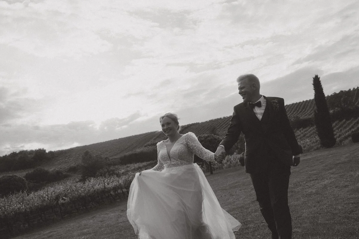 Das Brautpaar läuft lachend durch die Weinberge nach der kirchlichen Trauung auf dem Hofgut Donnersberg in Vendersheim.