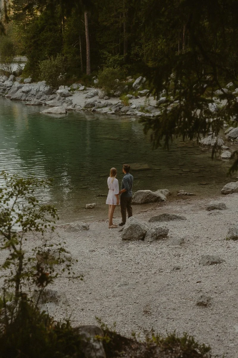 Ein Paar steht still am Ufer des Eibsees in Garmisch-Partenkirchen, eingefangen bei einem emotionalen Fotoshooting