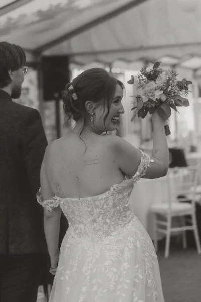 Die Braut hebt lächelnd ihren Blumenstrauß im Standesamt Lampertheim, begleitet von einem Hochzeitsfotograf aus Darmstadt mit Blick für echte Freude.