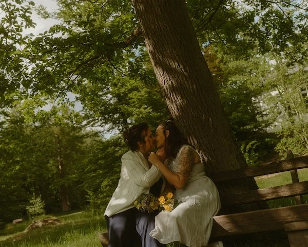 Zwei Bräute küssen sich für ihre Hochzeitsfotos in Darmstadt nach dem Standesamt an der Dianaburg.