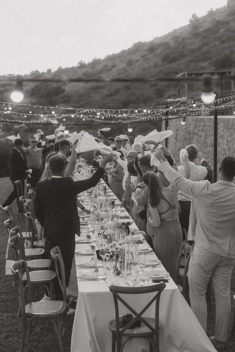 Gäste schwenken ausgelassen die Servietten zur Ankunft des Brautpaares bei einer Destination Wedding in Südtirol