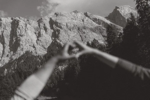 Schwarzweißaufnahme von Händen, die ein Herz bilden vor der Zugspitze in Bayern