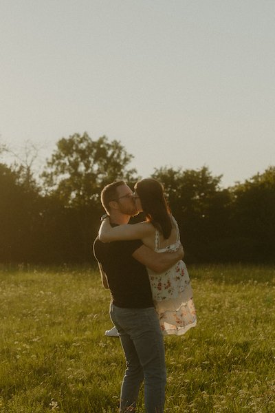 Ein verliebtes Paar hält sich eng umschlungen auf einer Wiese in Nomborn, festgehalten bei einem emotionalen Fotoshooting rund um Darmstadt in warmem Abendlicht.