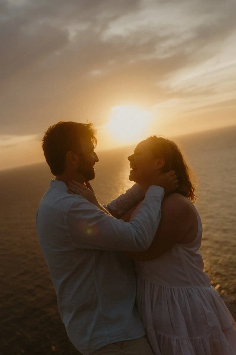 Lachendes Brautpaar vor einem Sonnenuntergang am Meer beim After Wedding Shooting in der Nähe von Sa Torre auf Mallorca