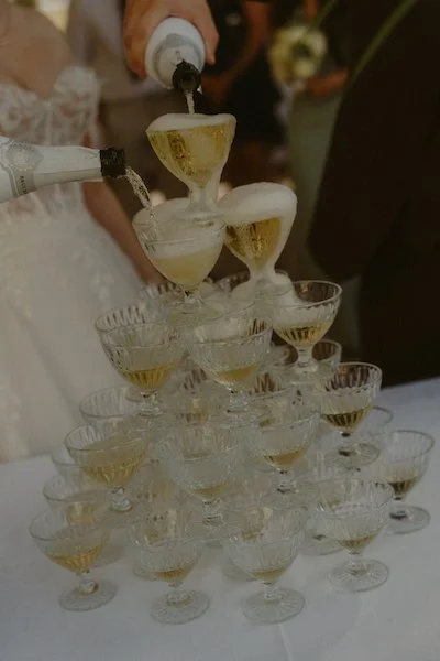 Das frisch gebackene Brautpaar gießt Champagner ein auf ihrer Hochzeit im Have'n'Hold am Herthasee in Holzappel.