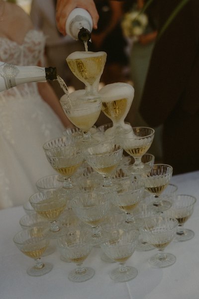 Das frisch gebackene Brautpaar gießt Champagner ein auf ihrer Hochzeit im Have'n'Hold am Herthasee in Holzappel.