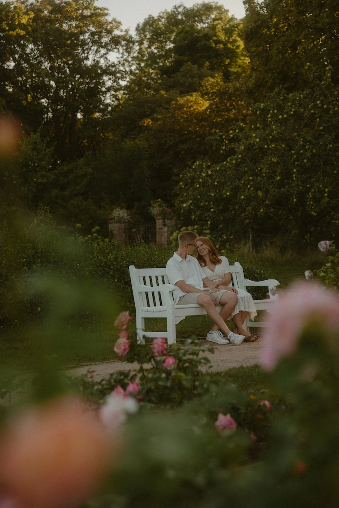 Ein verlobtes Paar sitzt eng beieinander auf einer Bank auf der Rosenhöhe Darmstadt, eingefangen bei einem emotionalen Fotoshooting in Darmstadt voller Nähe und Ruhe.