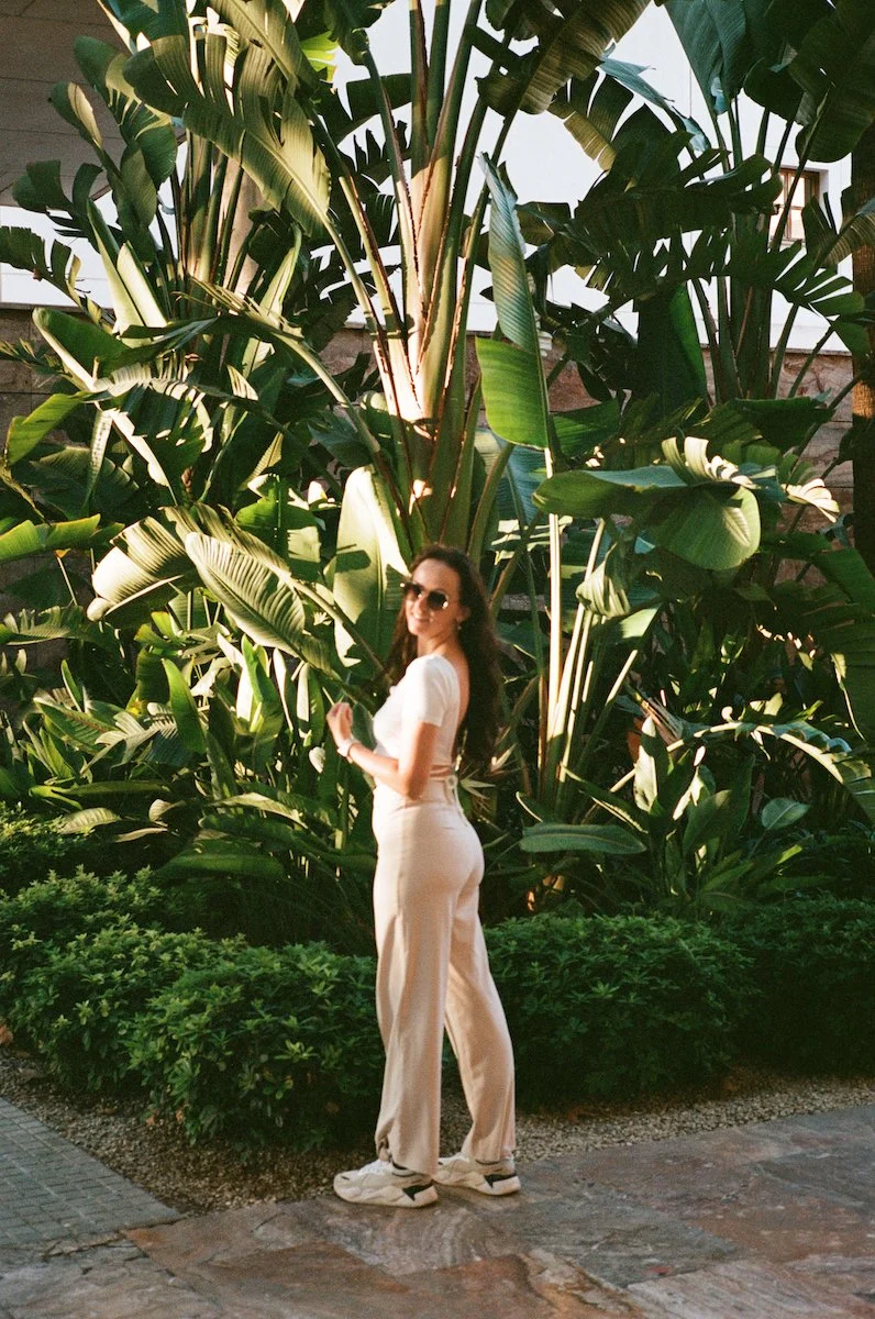 Der Hochzeitsfotograf aus Darmstadt steht entspannt zwischen Palmen im warmen Licht von Palma de Mallorca.