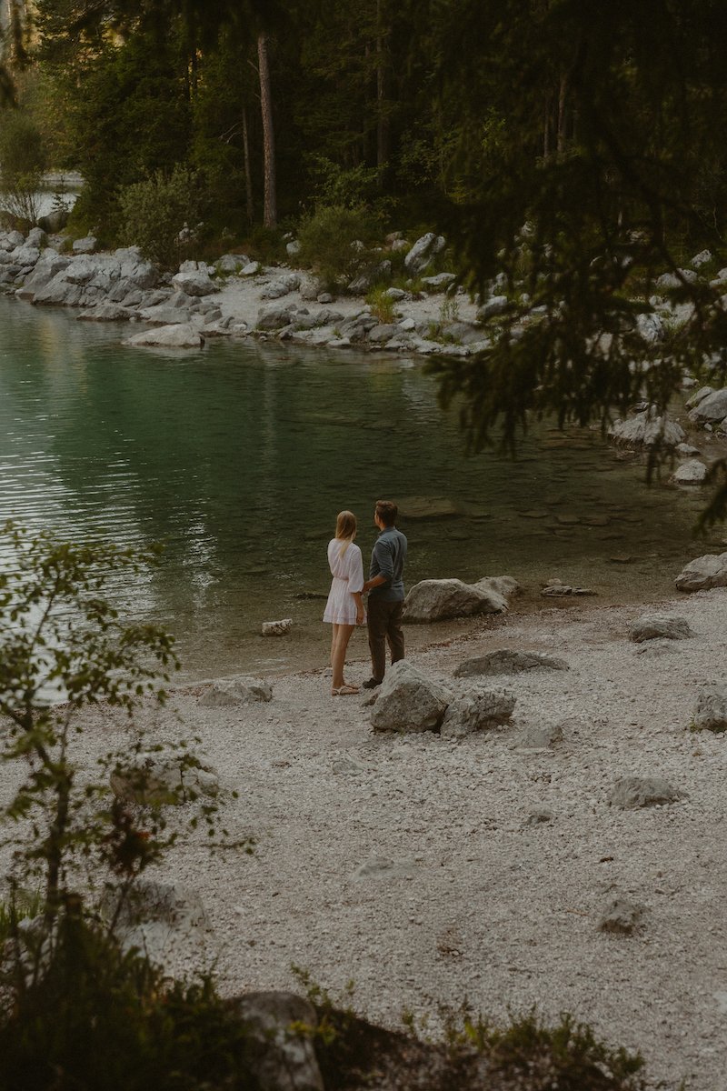Ein Paar steht am Ufer des Eibsees in Bayern und genießt den Ausblick in Stille