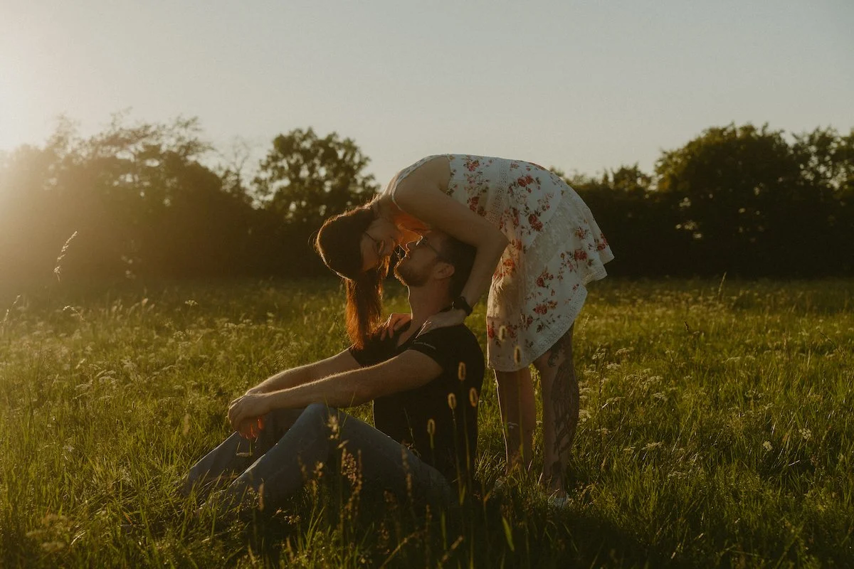 Ein verliebtes Paar küsst sich im goldenen Abendlicht auf einer Wiese in Nomborn, eingefangen bei einem emotionalen Fotoshooting voller Nähe.