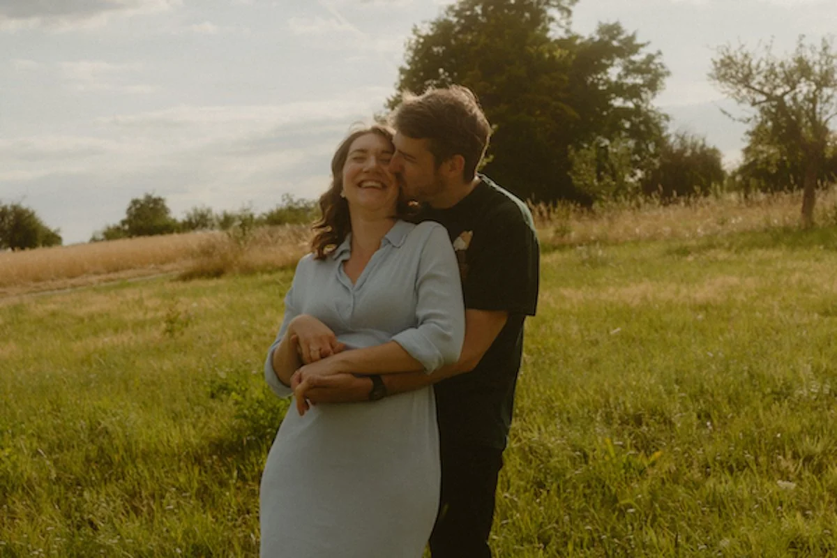 Ein werdendes Elternpaar lacht innig auf einem Bauernhof in Dreieich-Offenthal, festgehalten bei einem emotionalen Fotoshooting nahe Darmstadt mit natürlicher Nähe.