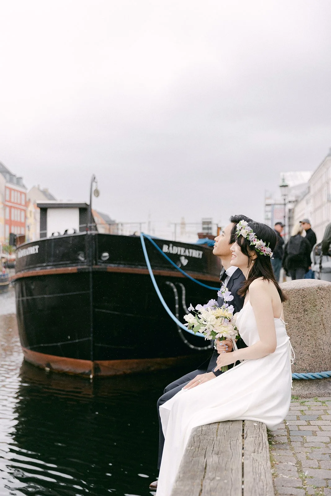 Wedding couple sitting at the deck of Nyhavn beside canal.jpg