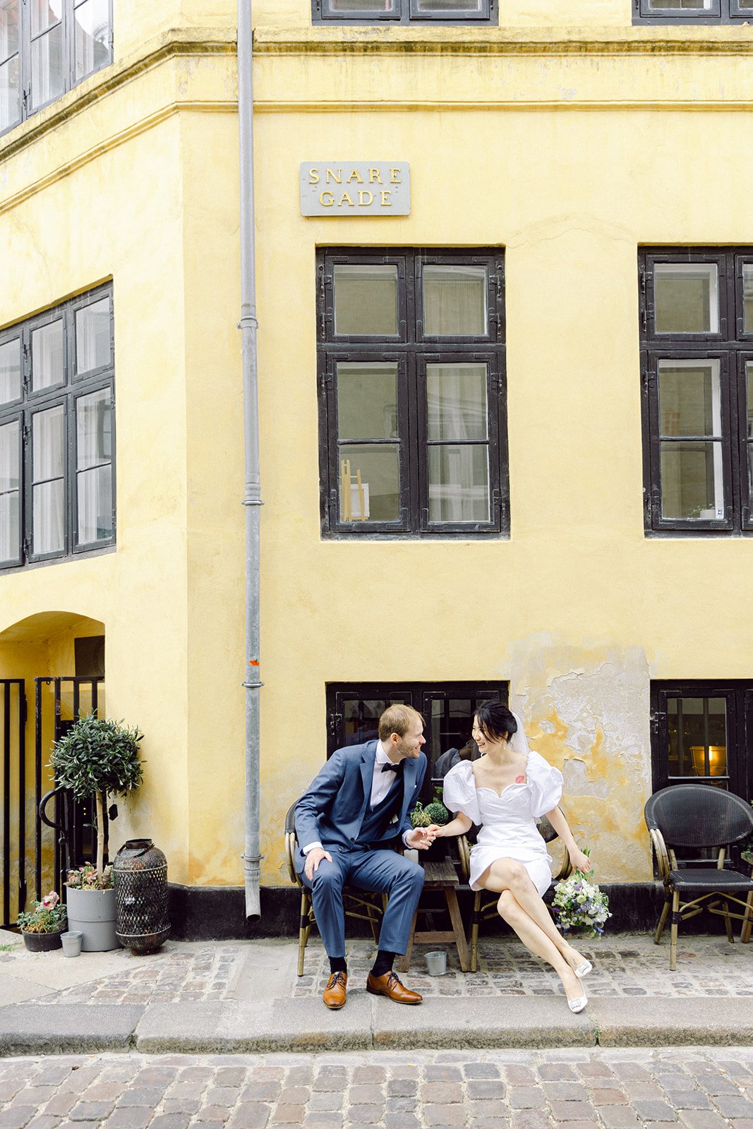 wedding couple kissing at a colourful street in Copenhagen Magstræde.jpg