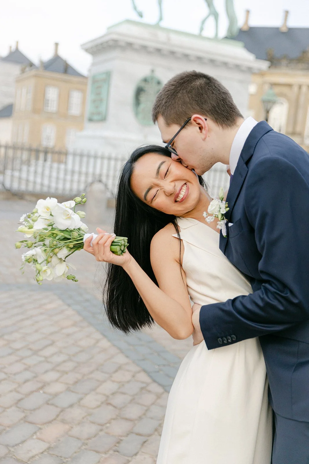 groom kissing bride in amalienborg slot after getting married in denmark.jpg