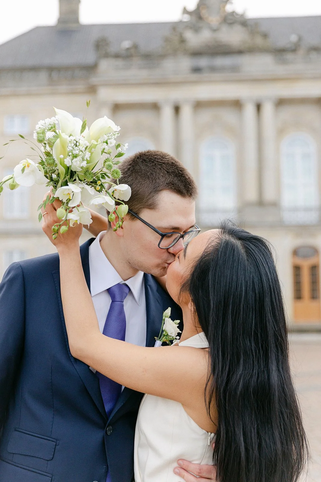 wedding couple kissing in amalienborg slot after getting married in denmark .jpg