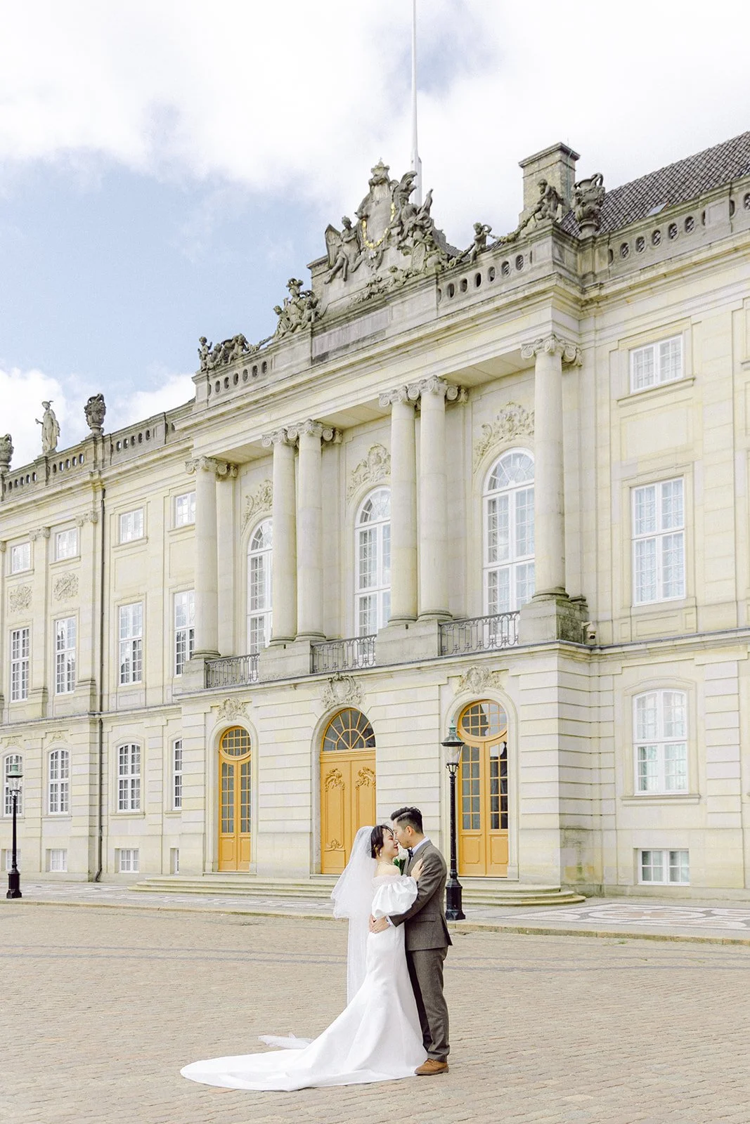Bride and groom kissing in amalienborg slot sunny day romantic elegant in denmark copenhagen.jpg