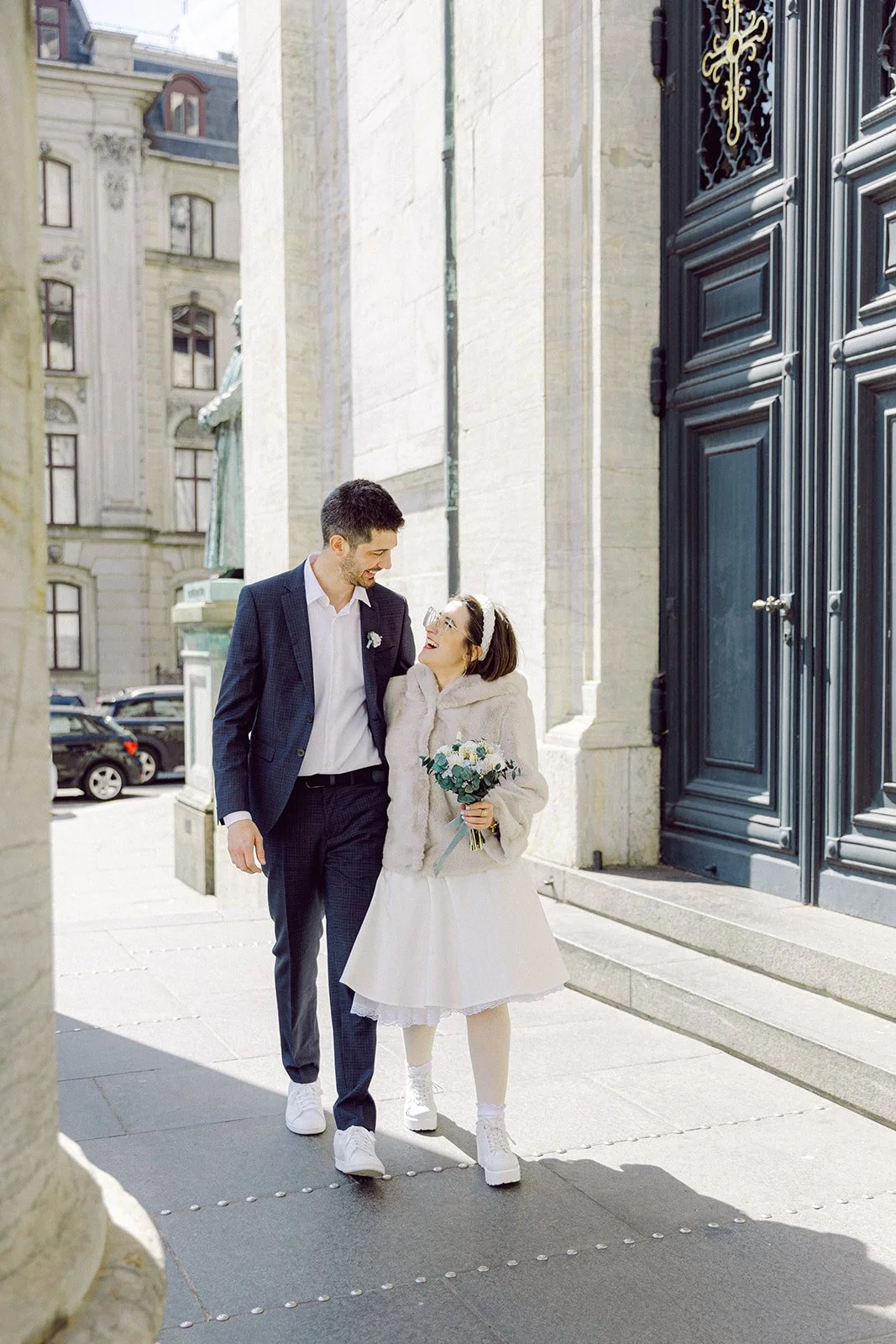 Couple walking in front of marble church after getting married in Copenhagen denmark in a sunny day.jpg