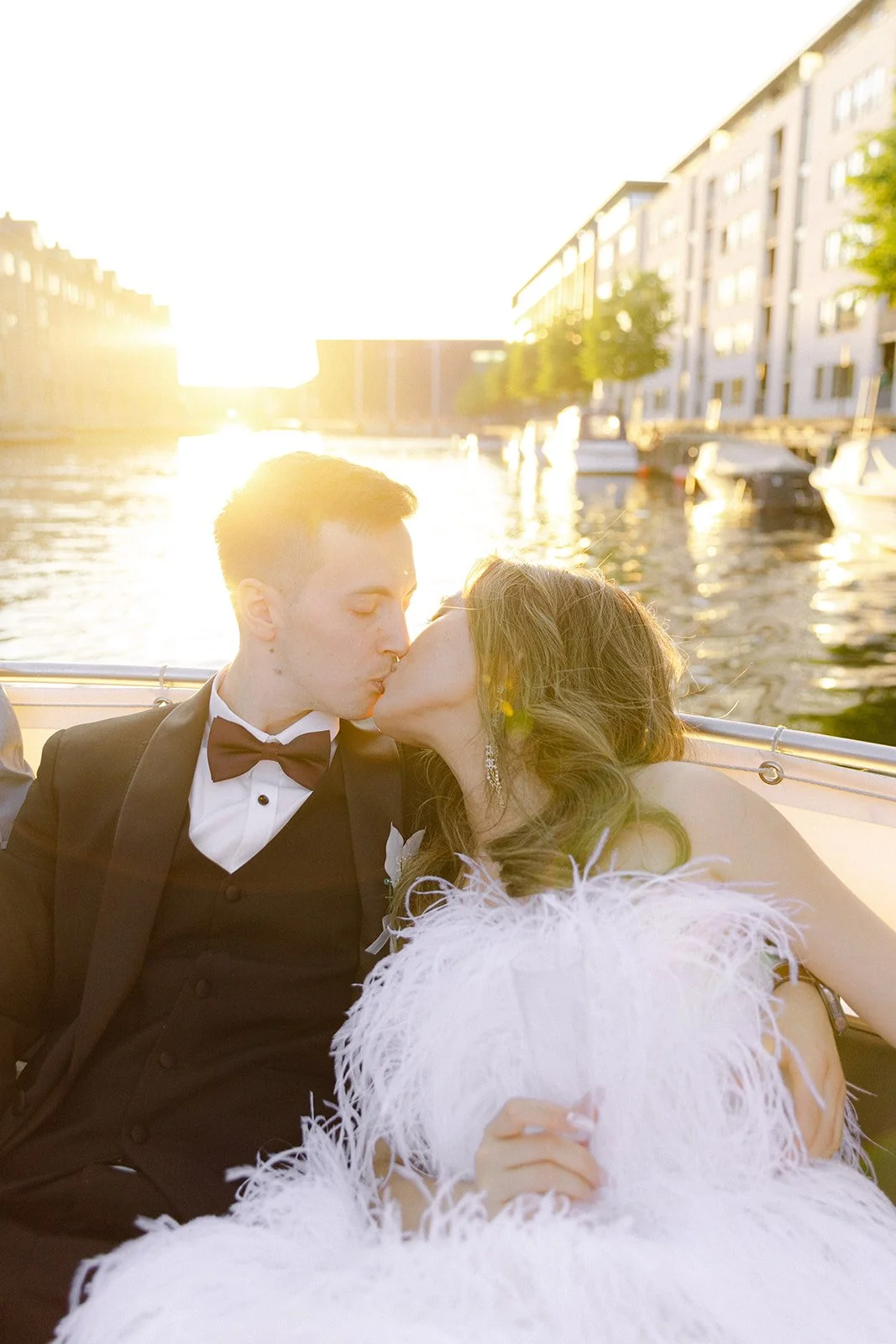 married bride and groom kissing on hey captain sunset session with sun glasses in copenhagen denmark on canal.jpg