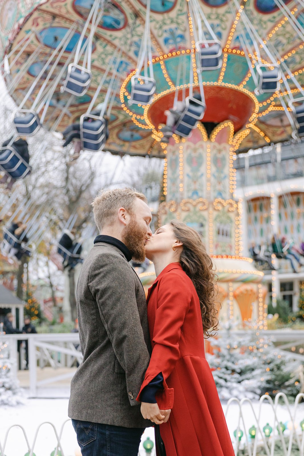 bride and groom kissing in Tivoli Carousel after getting married in copenhagen city hall in winter.jpg