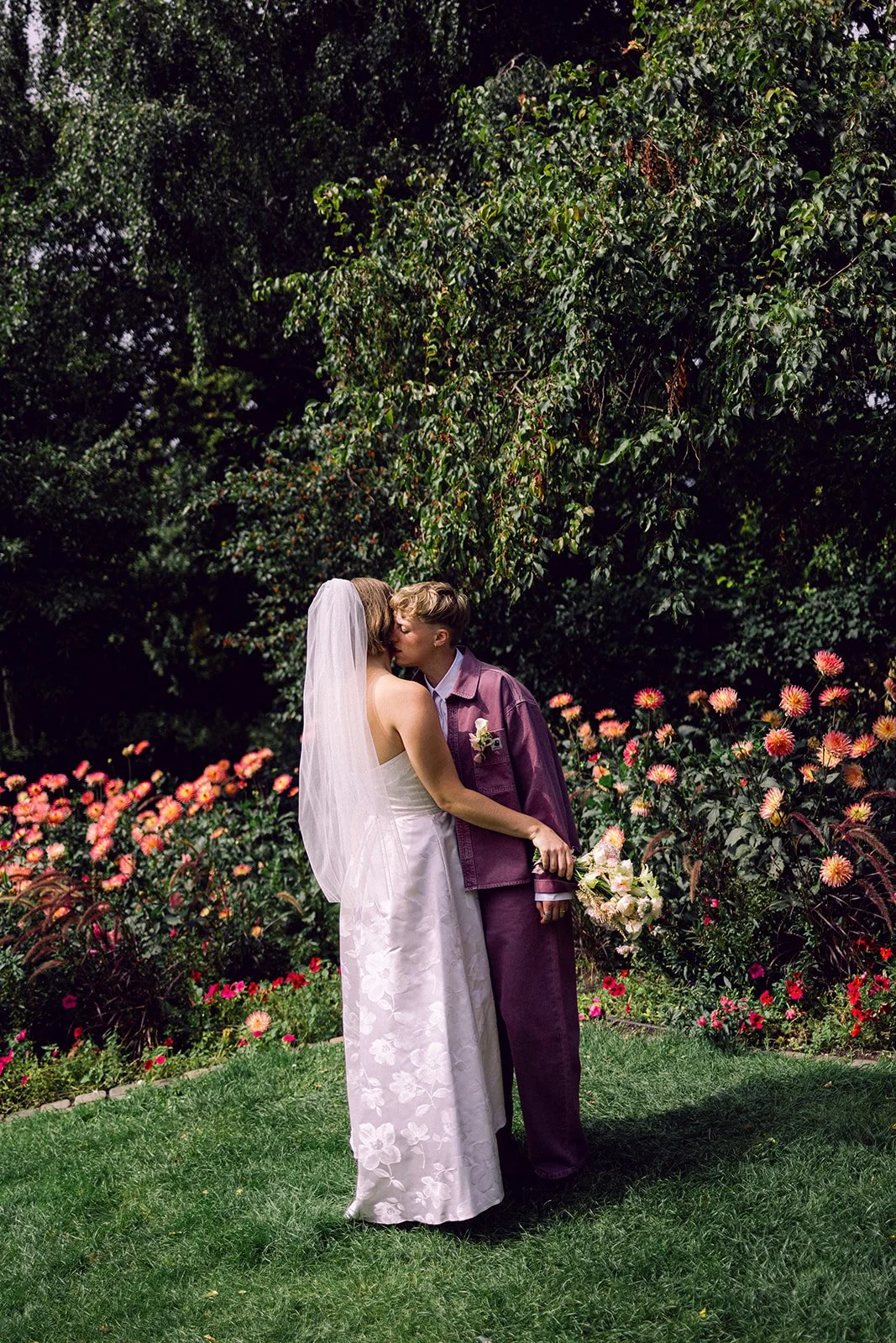 Same sex lgbtq+ couple in ørstedsparken on their wedding day sunny day in denmark portrait getting married kissing.jpg