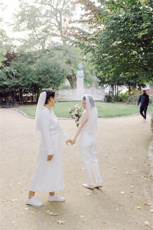 Same sex lgbtq+ couple walking in ørstedsparken on their wedding day sunny day in denmark.jpg