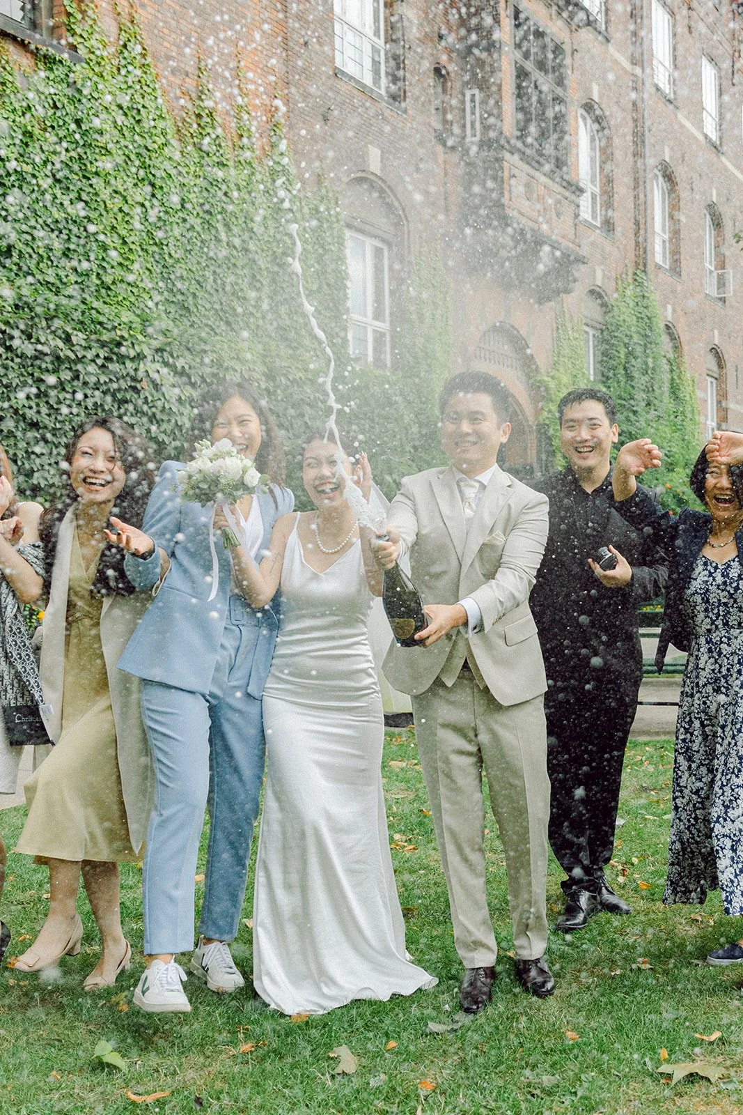 bride and groom in copenhagen city hall after getting married in denmark with confetti with guests champagne.jpg