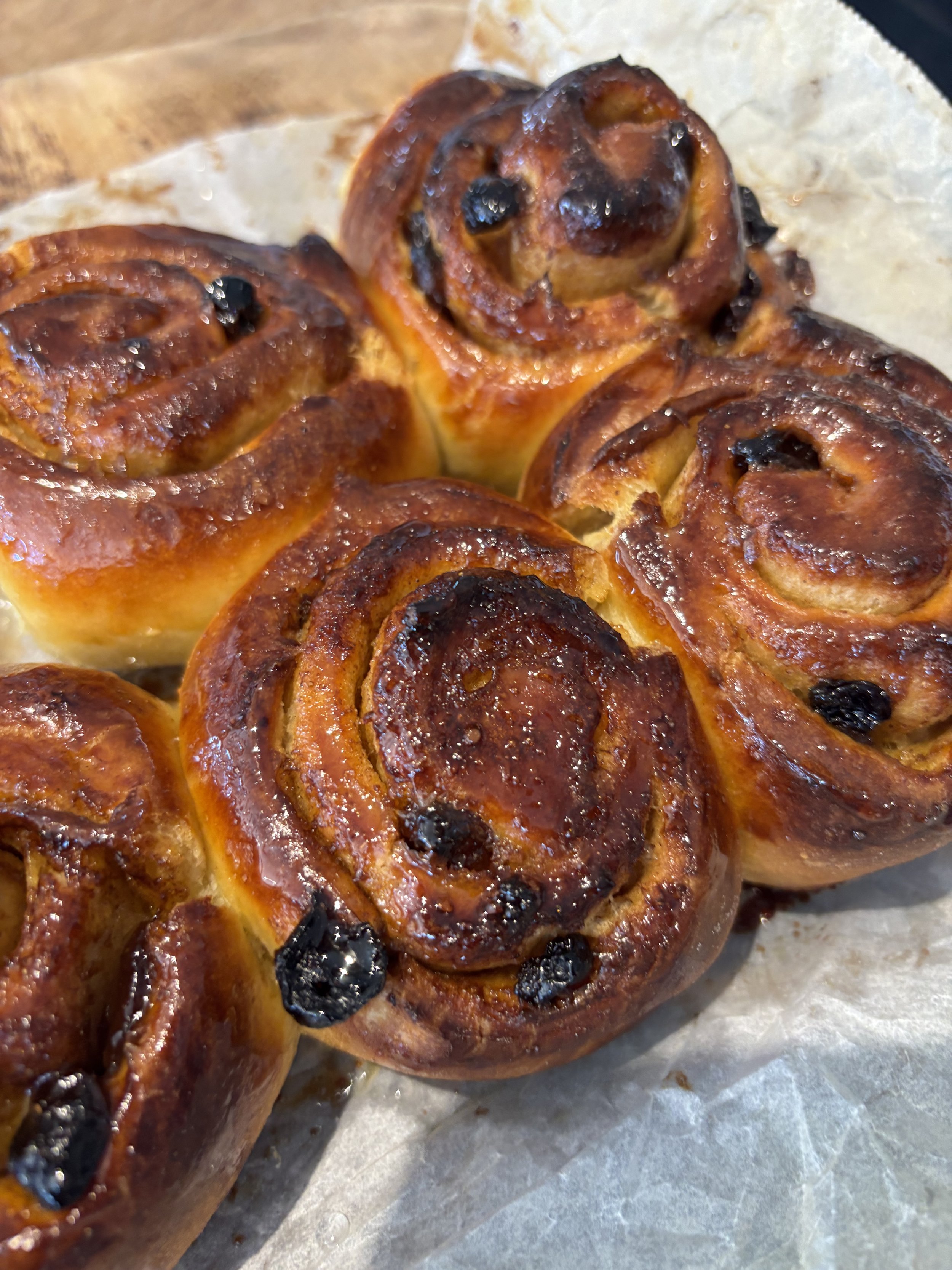 Tray of freshly baked round bread rolls with golden-brown tops.