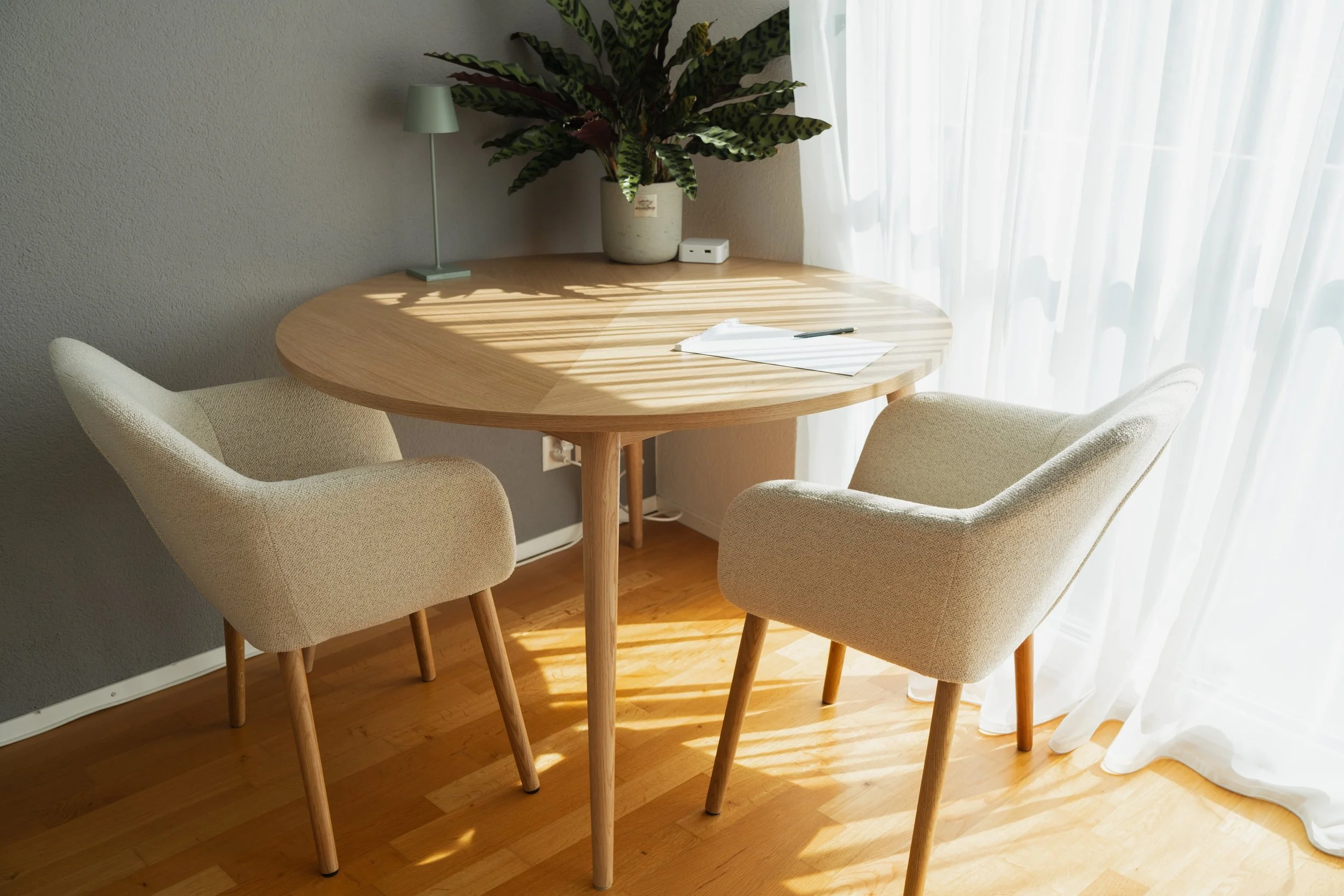 Der Coaching Raum in Hindelbank – ein ruhiger, heller Raum mit rundem Holztisch, zwei Sesseln und warmem Licht. Hier beginnt dein Coaching-Prozess.