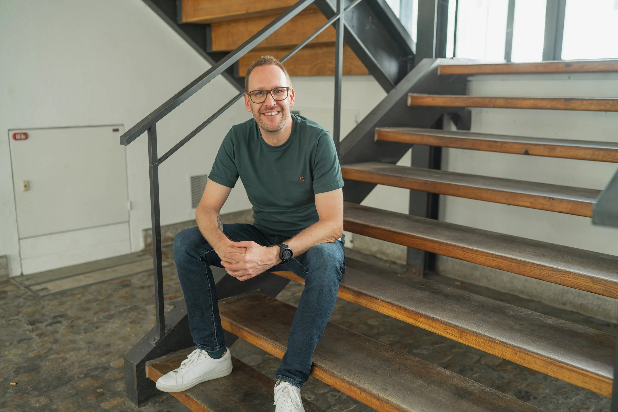 Mike Matter, Co-Active Coach aus Hindelbank, sitzt entspannt auf einer Treppe – nahbar, authentisch, auf Augenhöhe.