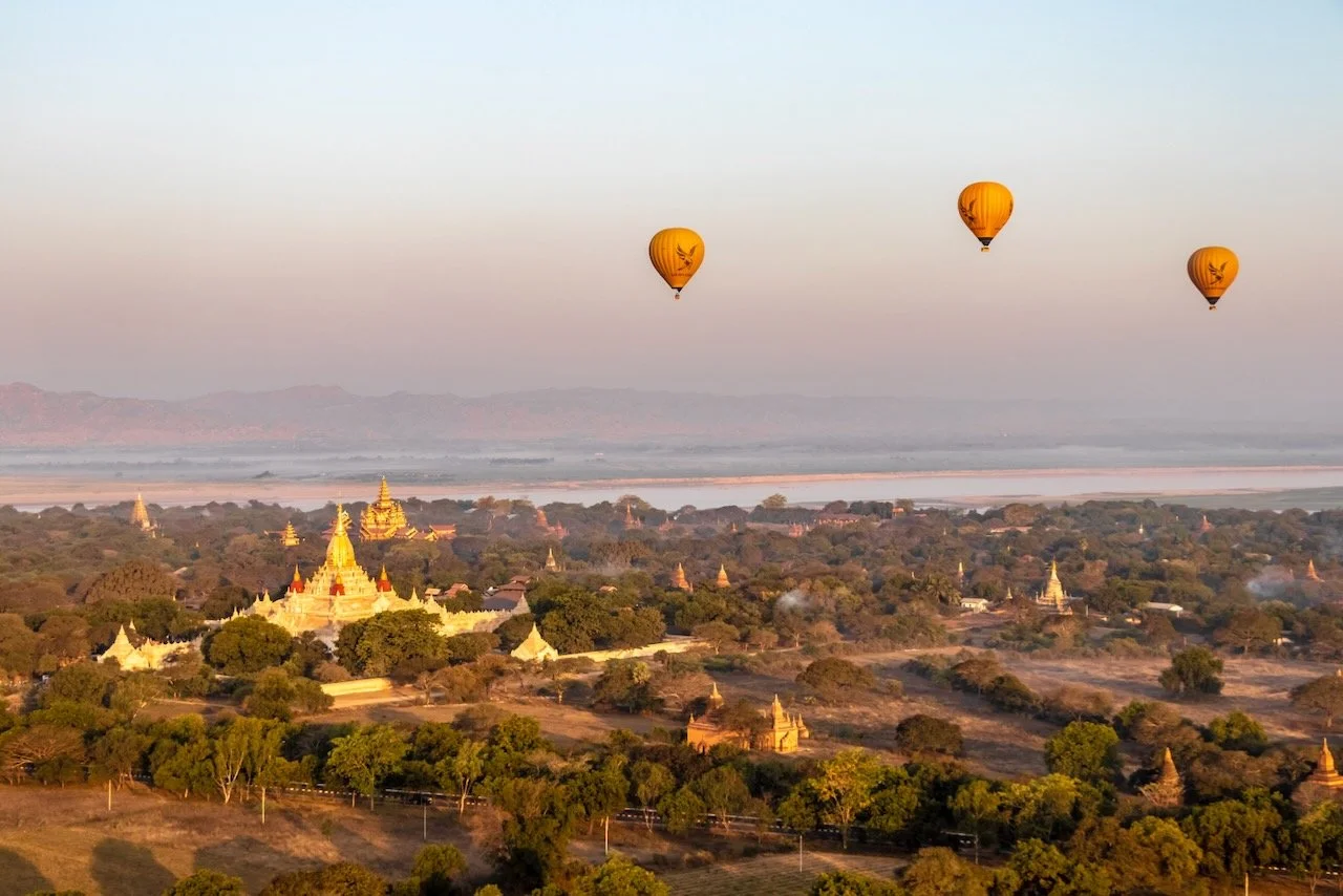 Ein Heissluftballon schwebt über der Landschaft Myanmars – weder am Boden noch angekommen, ein Bild für den Weg durch den Weder-noch-Zustand.