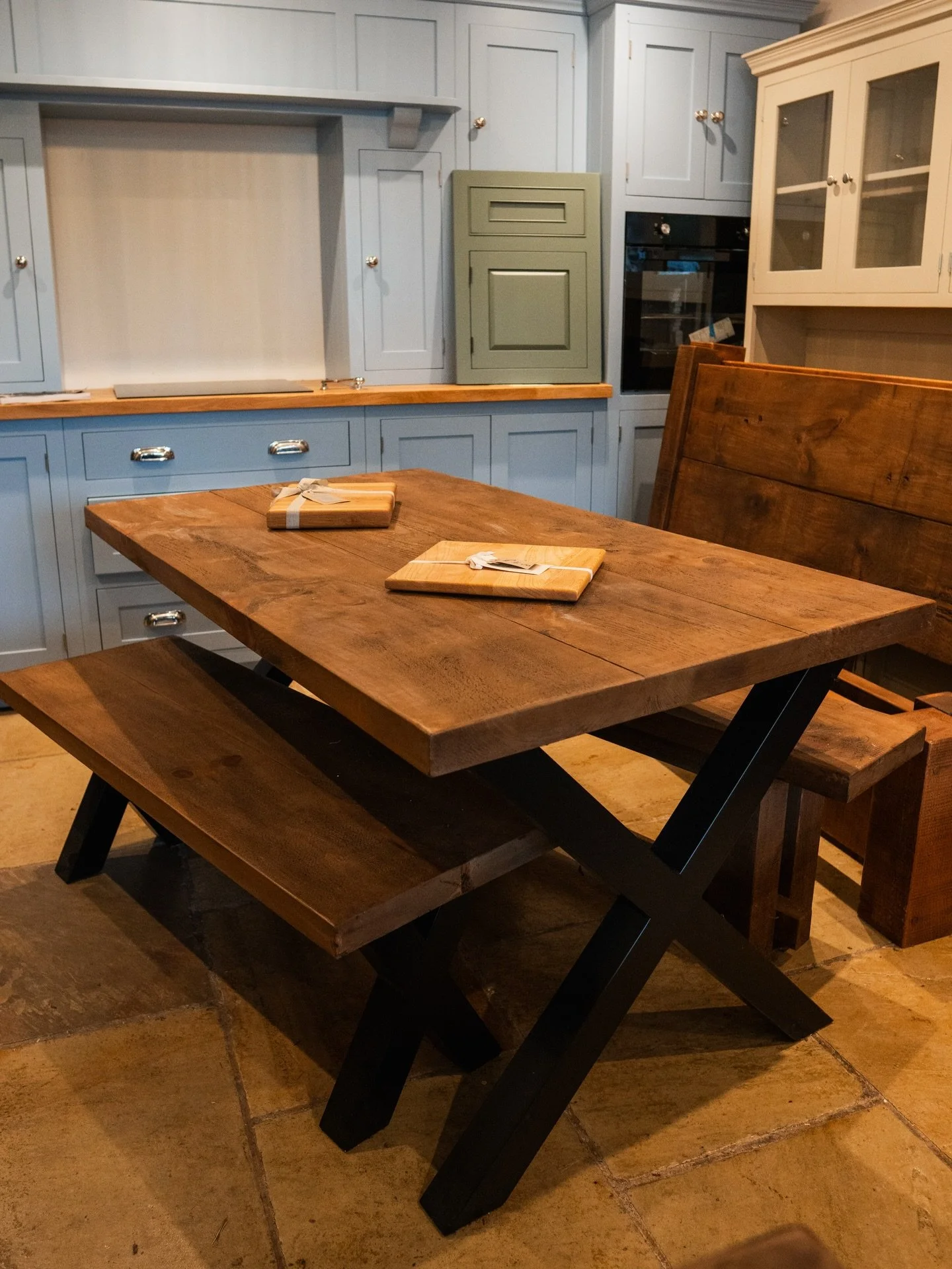 Beautiful X frame rough sawn plank table in stock now.

This can be paired with a matching bench, as seen here, or with chunky rough sawn plank chairs.