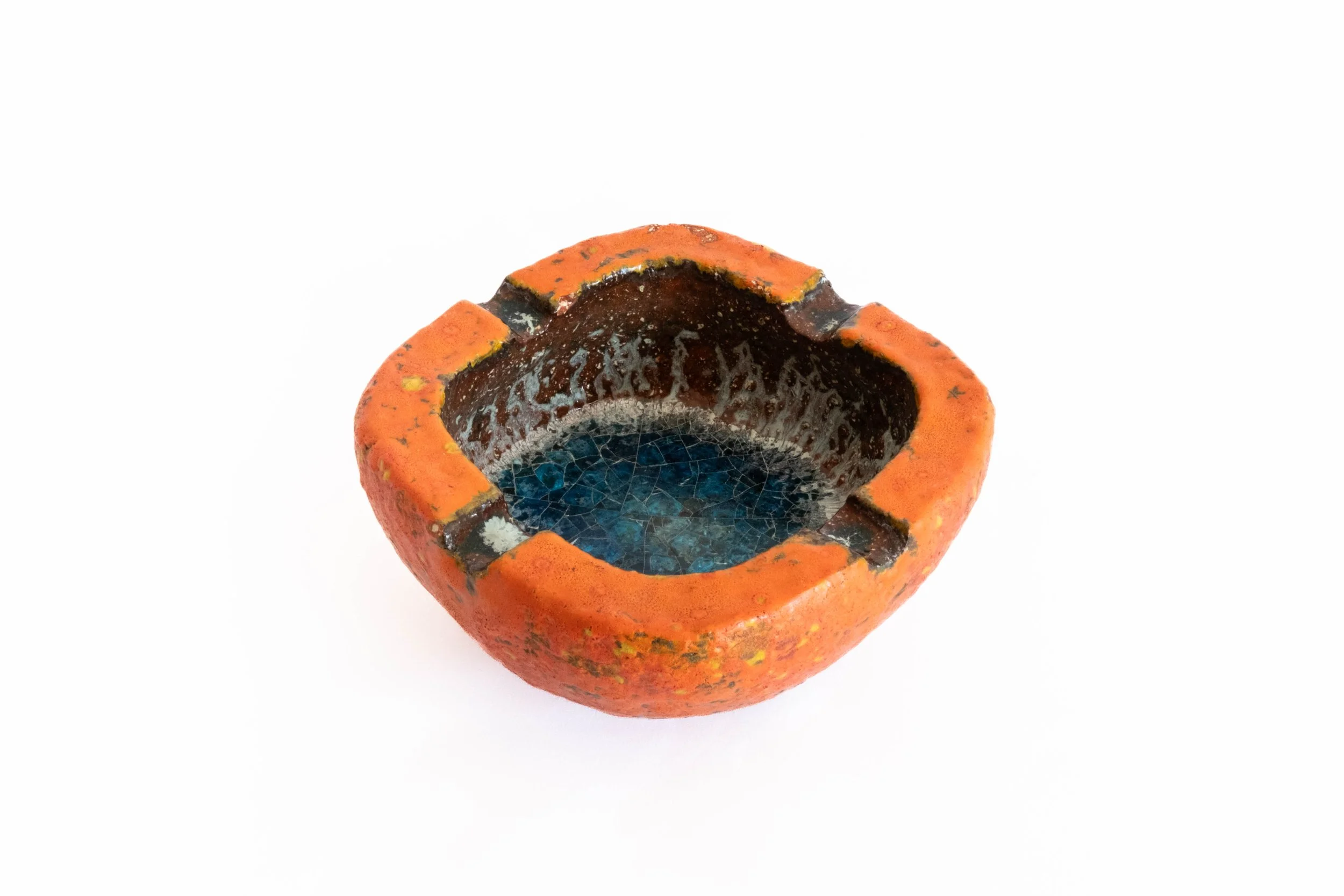 Decorative ceramic bowl with a textured orange outer surface and a glossy black and blue interior.