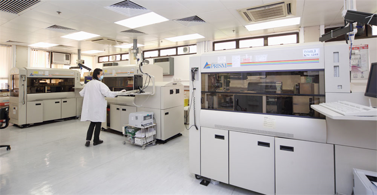 A scientist or technician working in a laboratory in the blood transfusion facility.
