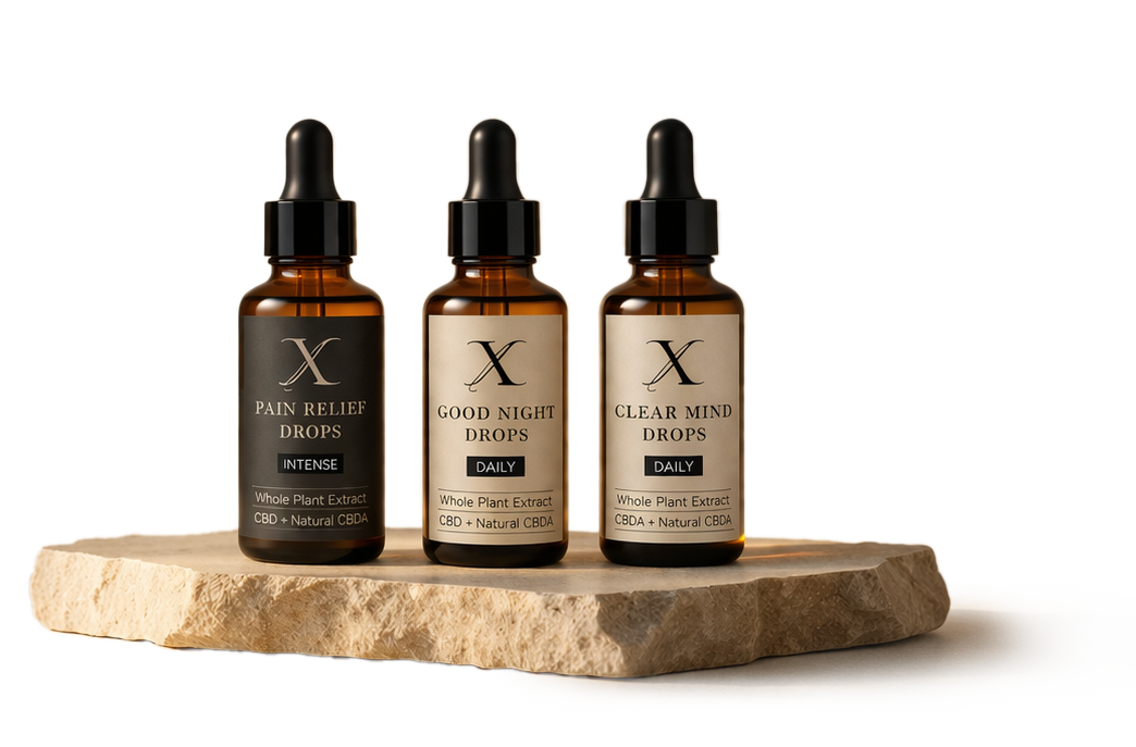 Tre matching brune glas drops-flasker med pipette, placeret på en sten, indeholdende CBD-olie med labels for smerte, god søvn og klar tankegang.