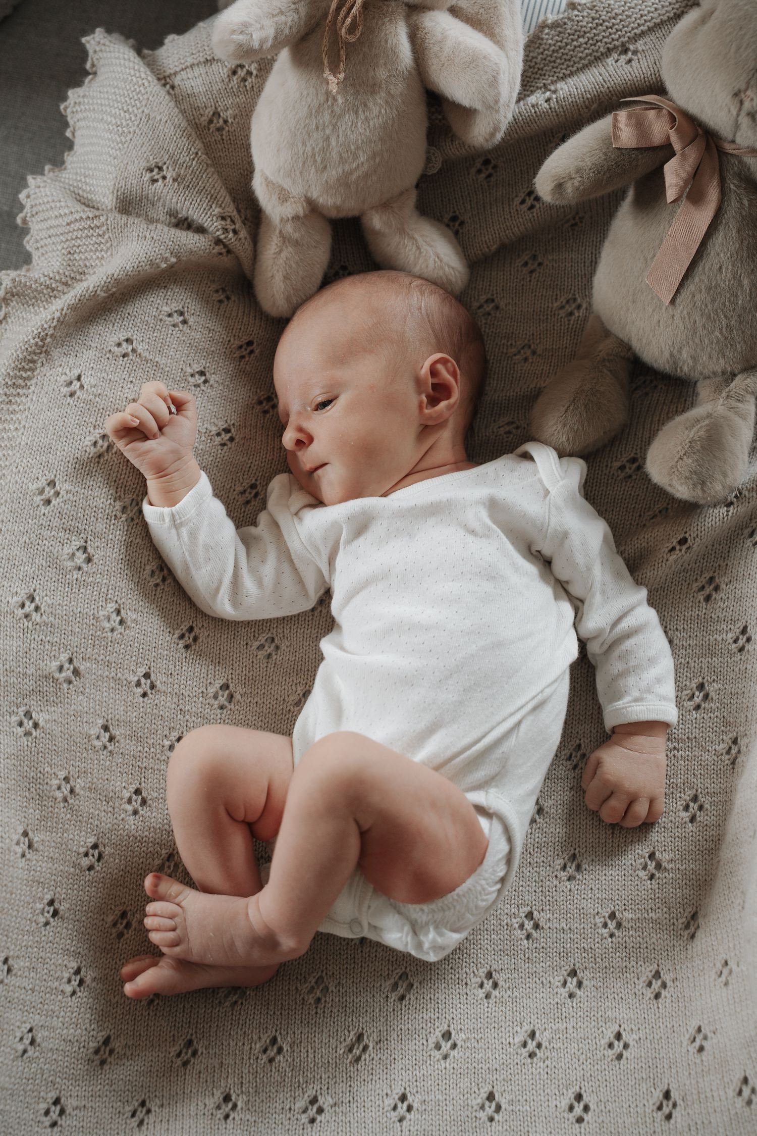 nyfødt baby dreng fotografering i eget hjem med bamser og babytæppe og hvid body