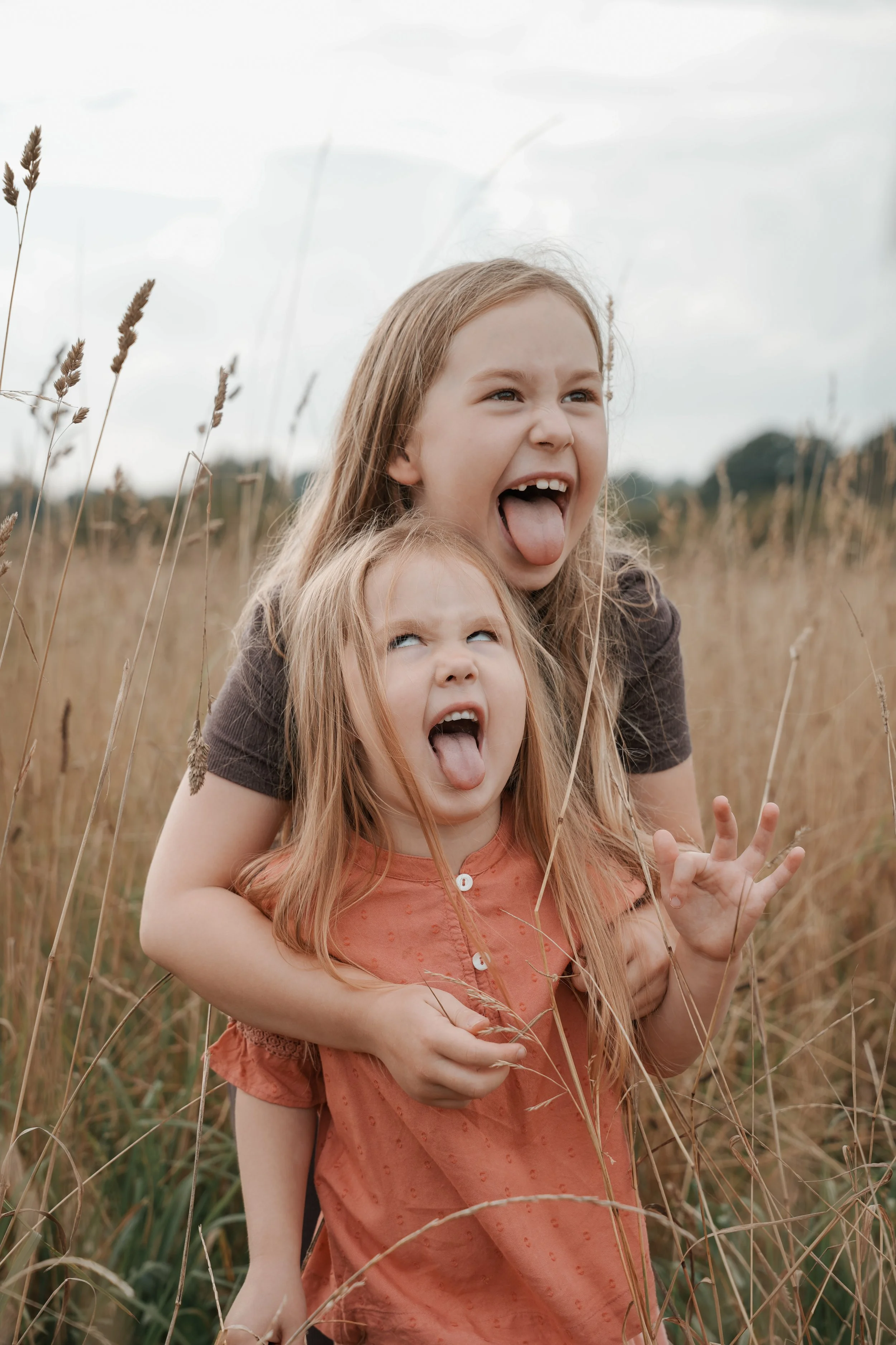 søstre som laver fjollede ansigter til fotograf til fotosession i espergærde, nordsjælland, københavn