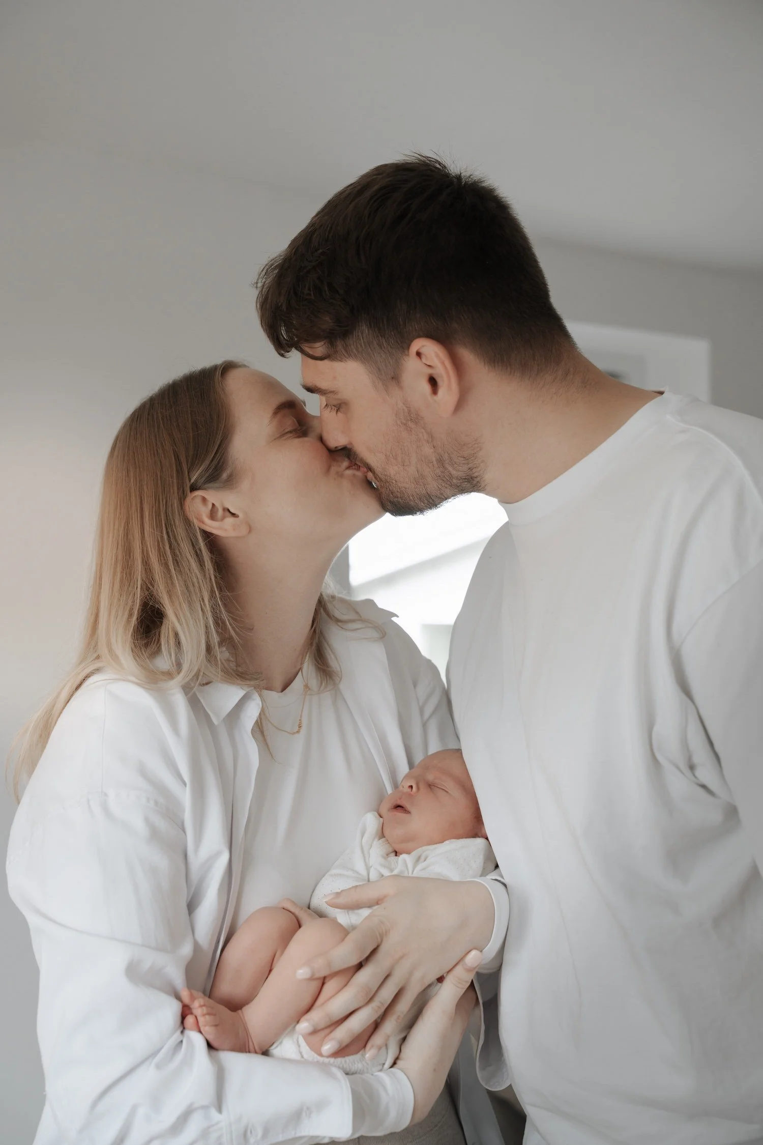 nybagte forældre med deres nyfødte baby dreng i armene, professionel fotografering i forældrenes eget hjem