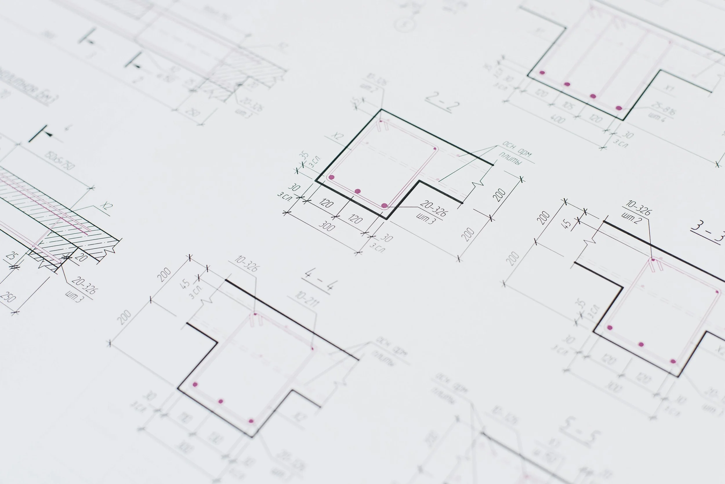 Architectural blueprint with detailed floor plans and measurements in black, pink, and green ink.