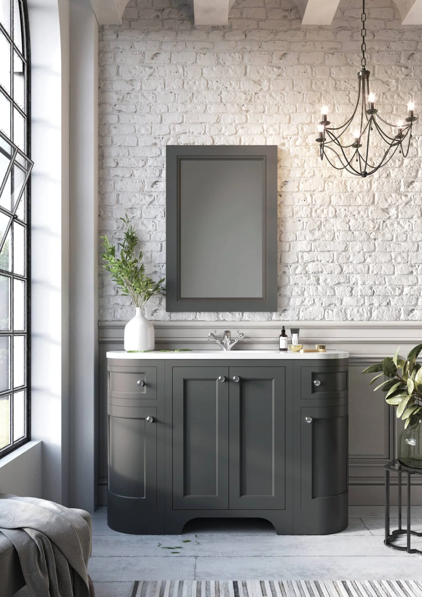 Bathroom with white brick wall, grey vanity with mirror, black chandelier, large window, and green plants.